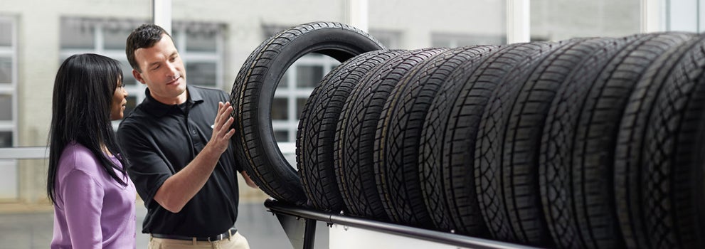 Subaru service representative showing customer a tire. | Flow Subaru of Charlottesville in Charlottesville VA