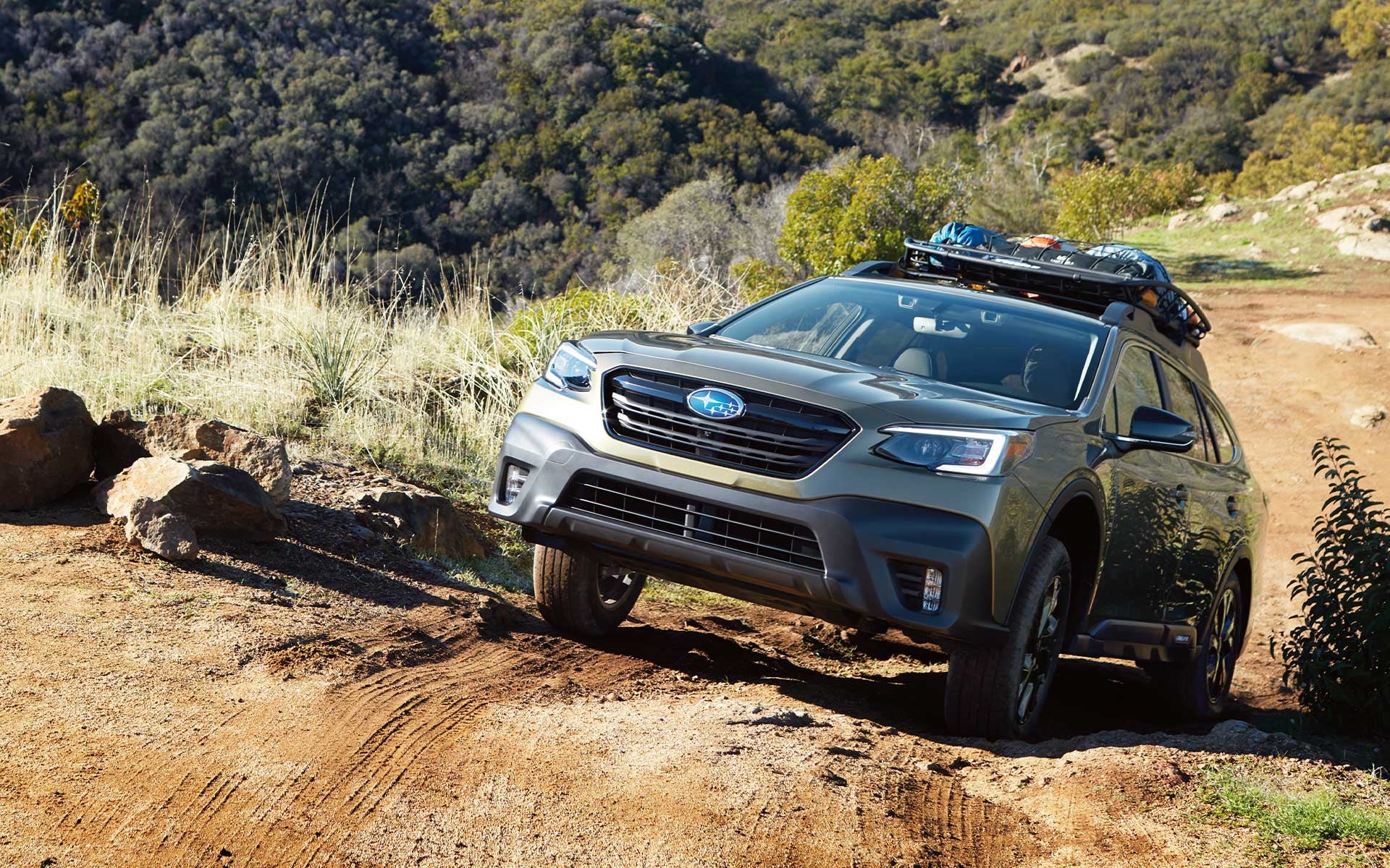 Subaru Outback driving on a rocky off-road trail through a natural landscape, demonstrating off-road capability